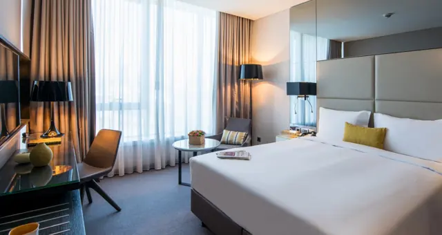 Chambre double lumineuse avec bureau et grandes baies vitrées, hôtel Rotana Istanbul