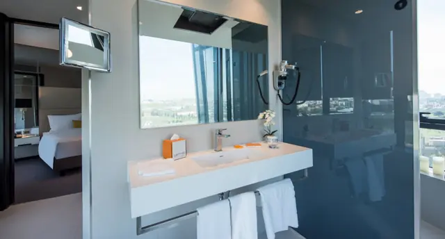 Salle de bains avec vasque et miroir, vue sur la ville