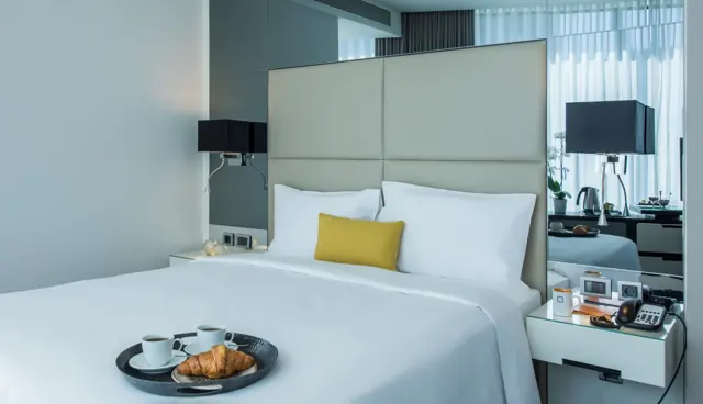 Lit double avec plateau de petit-déjeuner, croissant et café