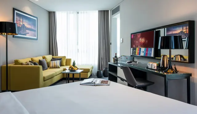 Chambre avec lit double, canapé et bureau