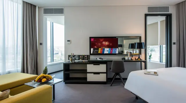 Chambre avec coin salon, bureau et télévision