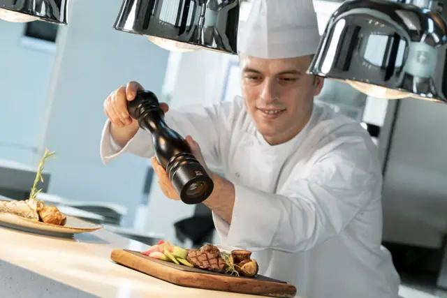 Chef assaisonnant une pièce de viande