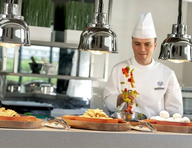 Chef préparant un plat au buffet
