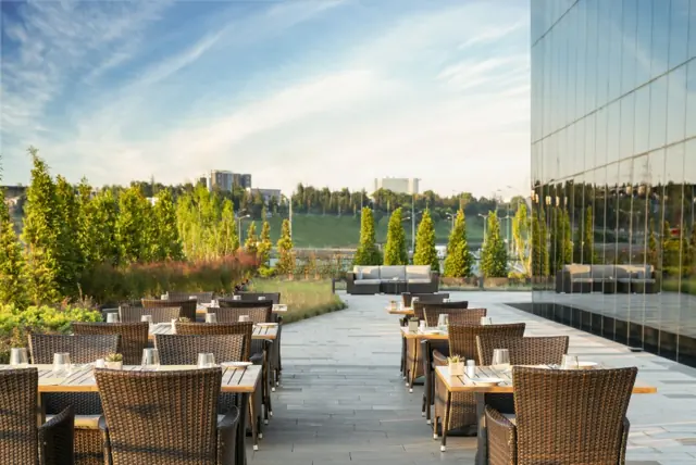 Terrasse extérieure du restaurant entourée de verdure