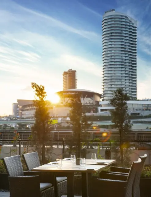 Table en terrasse au coucher du soleil face aux tours de la ville