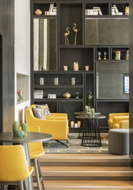 Coin salon avec fauteuils jaunes et bibliothèque