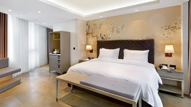 Chambre Deluxe avec grand lit, papier peint à motifs floraux et banquette, hôtel Wanda Vista Istanbul
