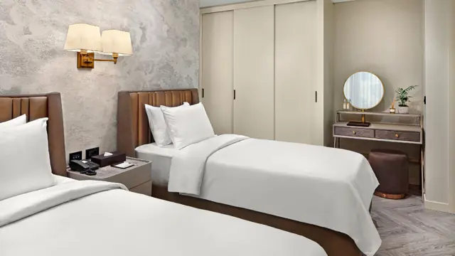Chambre avec deux lits simples et coiffeuse
