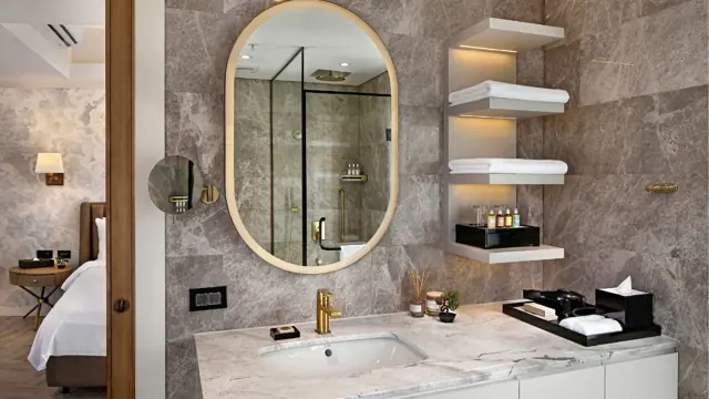 Salle de bains avec douche vitrée et miroir ovale