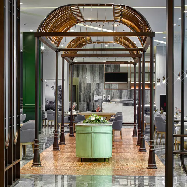 Entrée du restaurant sous une verrière en fer forgé